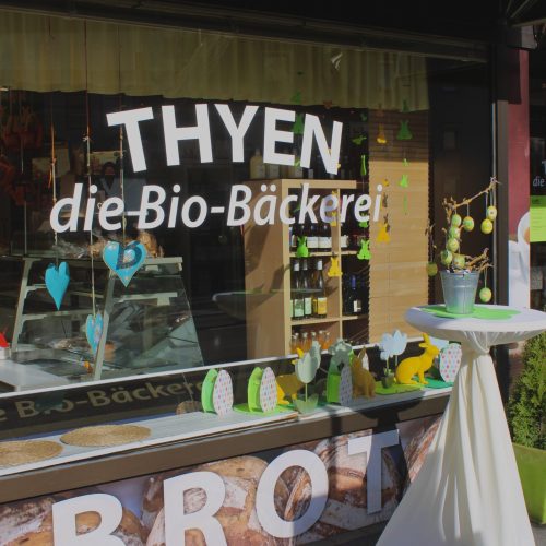 Eingang von Biobäckerei-Thyen dekoriert mit bunter Osterdekoration